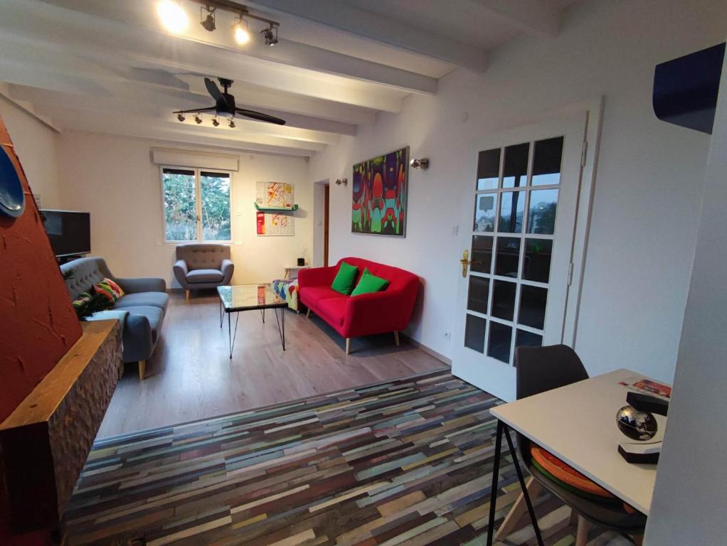 ein Wohnzimmer mit einem roten Sofa und einem Tisch in der Unterkunft Chemin des Vignerons in Metz