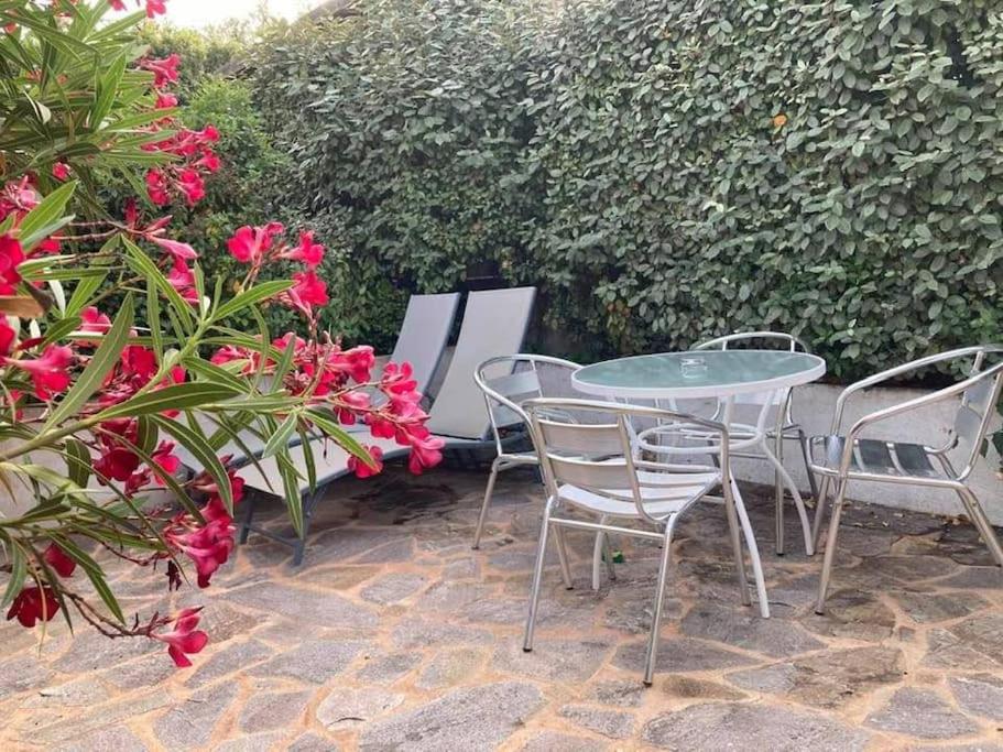 - une terrasse avec une table, des chaises et des fleurs dans l'établissement Studio à 200m du centre ville de Porto Vecchio., à Porto-Vecchio