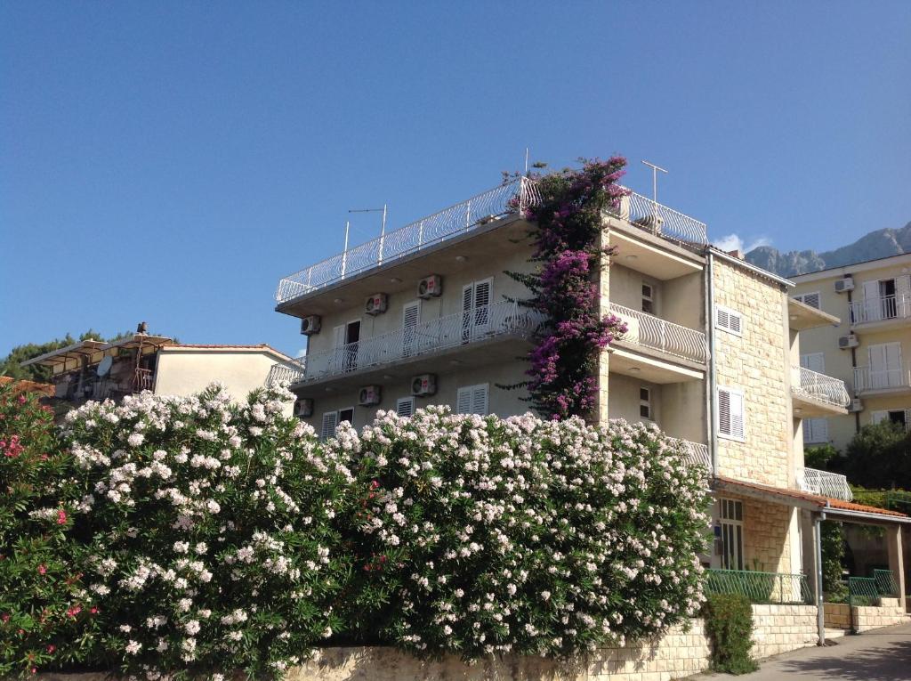 a building with flowering bushes in front of it at Bed & Breakfast Batosic Makarska in Makarska