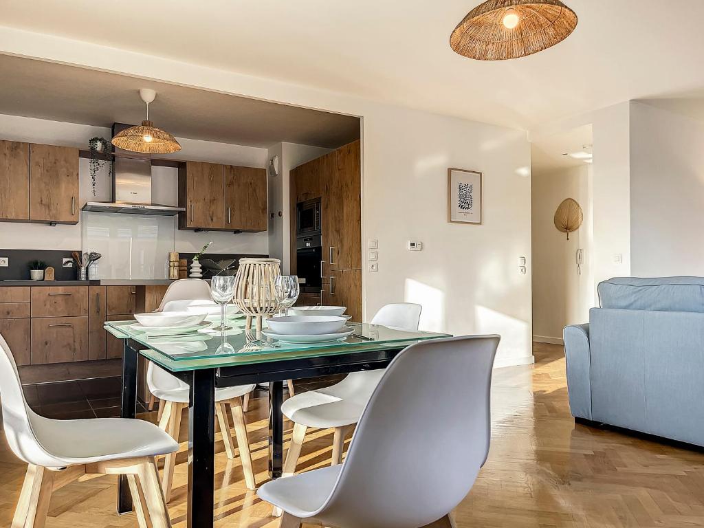 comedor y cocina con mesa y sillas en "L'orchidée", confort et calme proche de Paris en Ermont