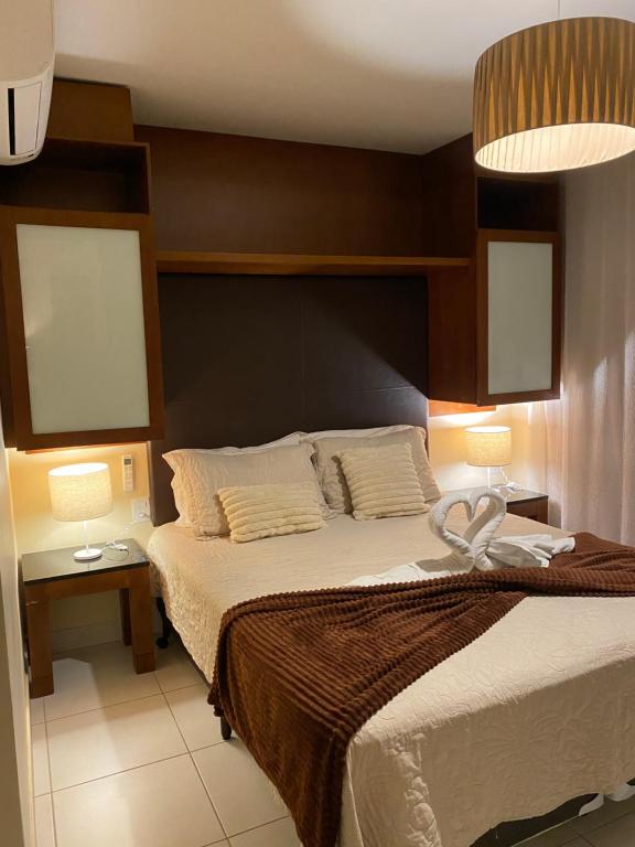 een slaapkamer met een groot bed met 2 lampen bij VG Sun Cumbuco Bangalô Vista Mar in Cumbuco