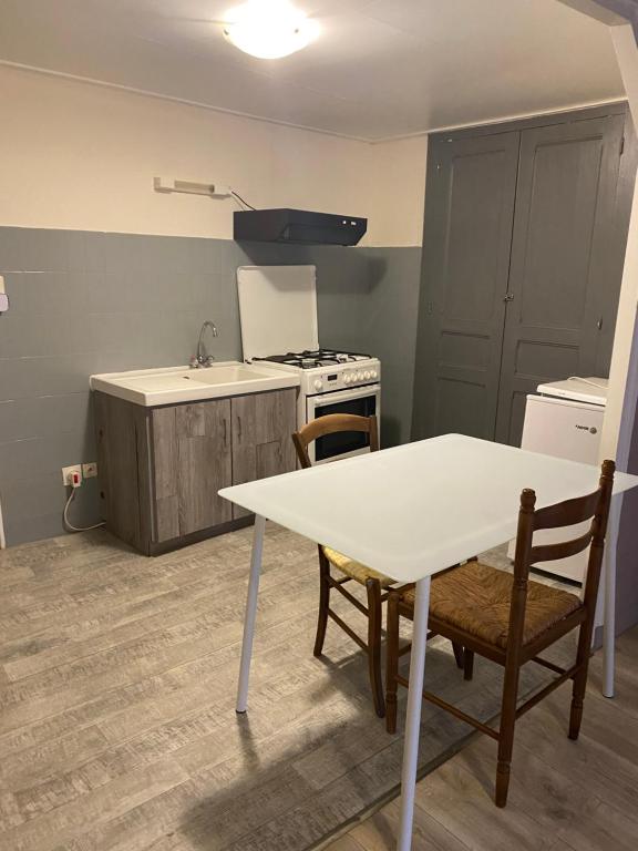 a kitchen with a table and chairs and a sink at L’étape in Massiac