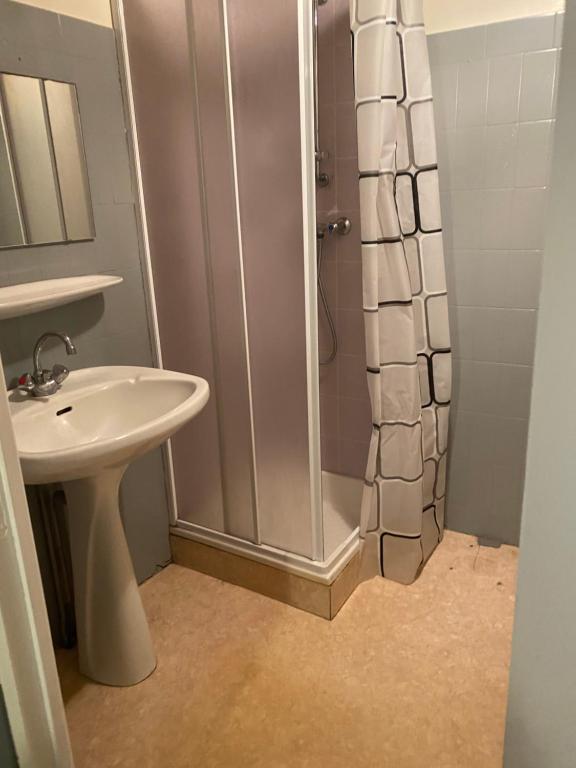 a white bathroom with a shower and a sink at L’étape in Massiac
