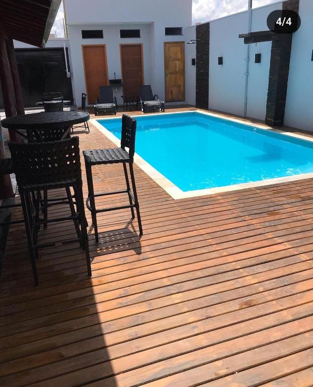 einen Pool mit 2 Stühlen und einem Tisch auf einer Terrasse in der Unterkunft Área de laser Gabata in Delfinópolis