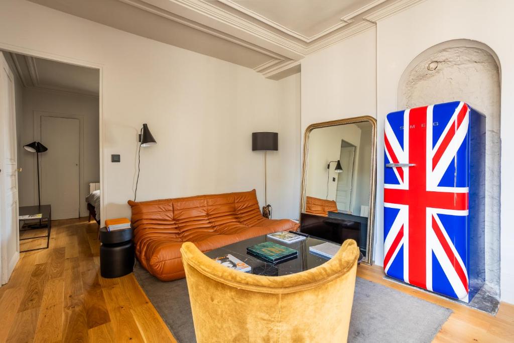 een woonkamer met een bank en een vlag op de muur bij Bail Mobilite Luxe Le Marais in Parijs