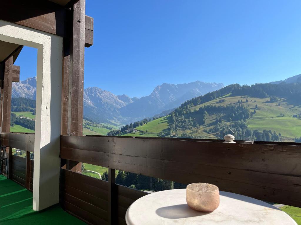 a table on a balcony with a view of mountains at Malejo - HochkönigCard - Pool - Ski-in & Ski-out in Maria Alm am Steinernen Meer