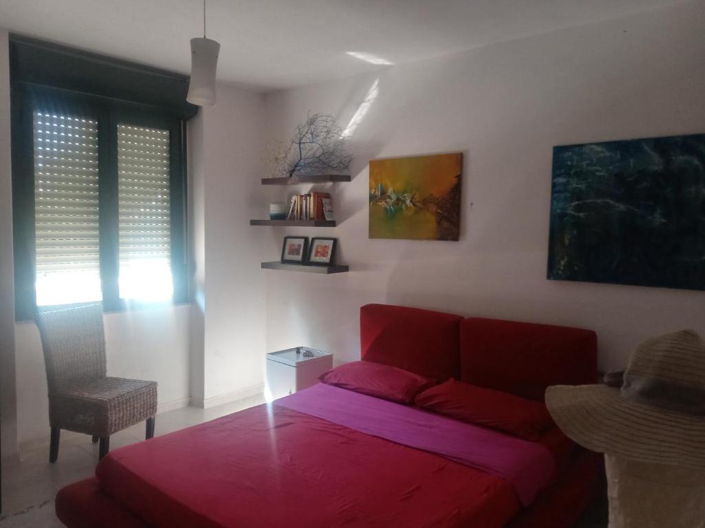 sala de estar con sofá rojo y mesa en camere Olmedo - 10 minuti da Alghero, en Olmedo