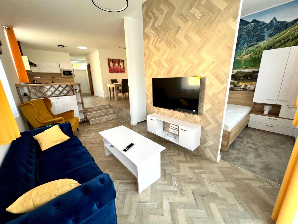a living room with a blue couch and a tv at Apartmány Lucia in Poprad