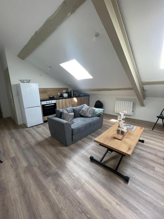 ein Wohnzimmer mit einem Sofa und einem Tisch in der Unterkunft T2 Cosy - Terrasse - Proche du stade - 401 in Saint-Étienne