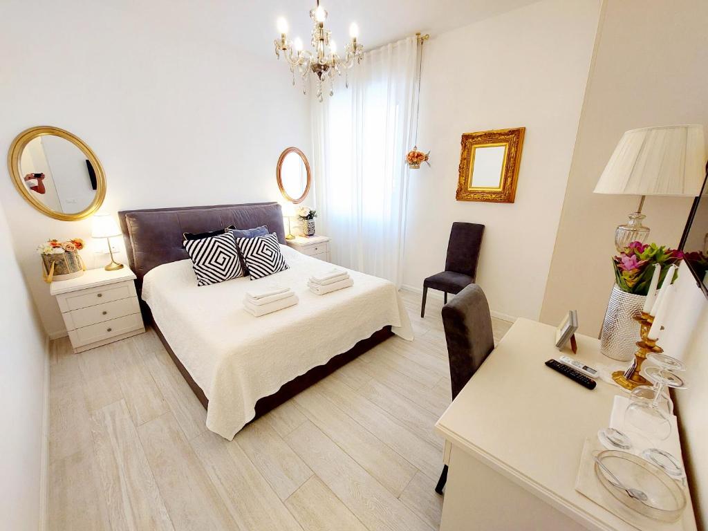 een slaapkamer met een bed, een bureau en een spiegel bij Piccolo Mondo Verona in Verona