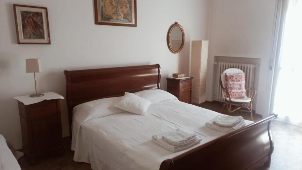 una camera con letto, sedia e specchio di OLA apartment a Mantova