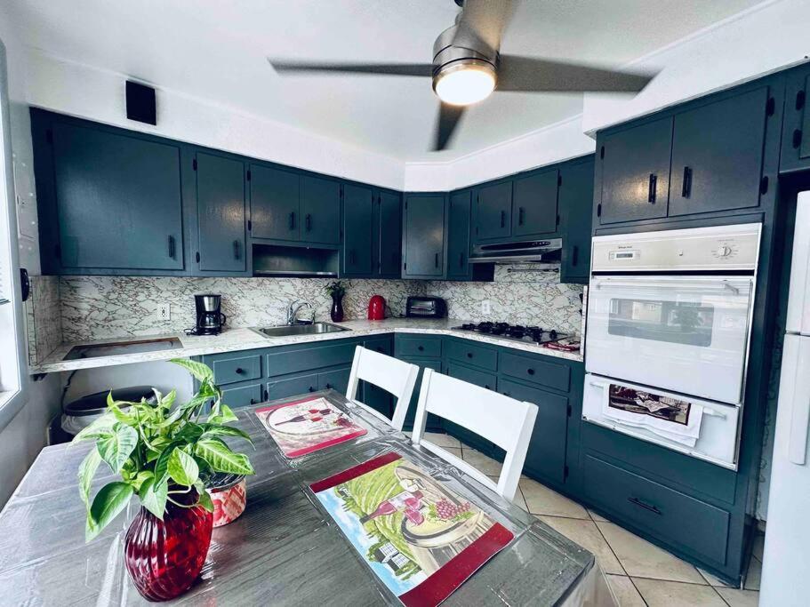 una cocina con armarios azules y una mesa con sillas en Cozy 2 bedrooms apartment near nyc w/free parking, en Bloomfield