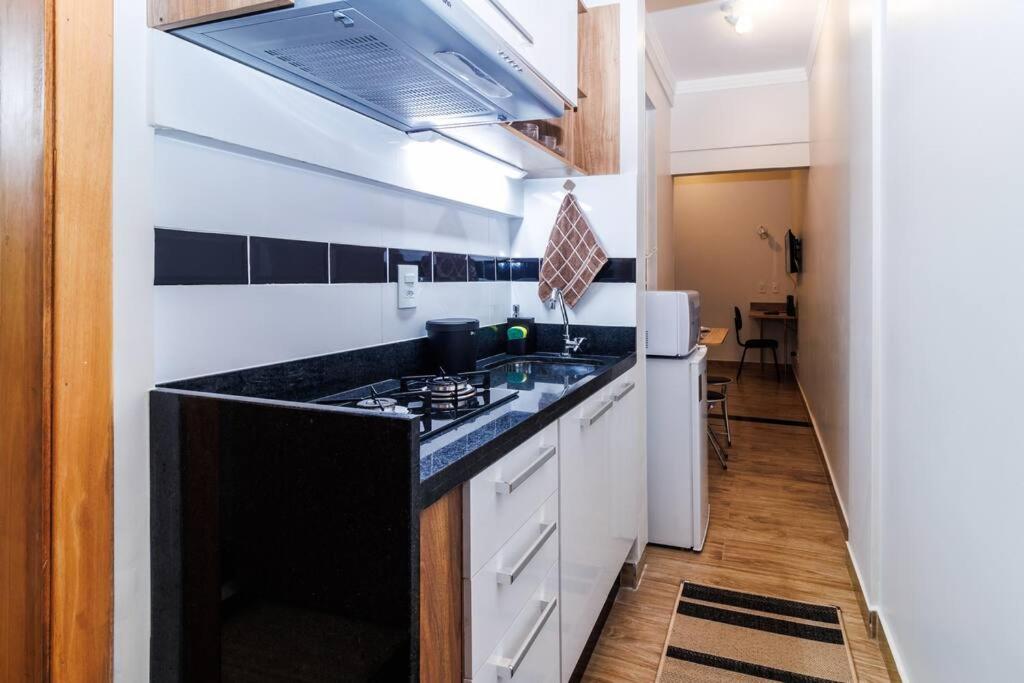 a kitchen with a black counter top and a stove at Studio 112 Campinas SP in Campinas