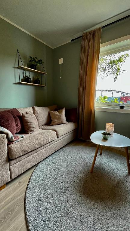 a living room with a couch and a table at Strøken liten leilighet i Svolvær. in Svolvær