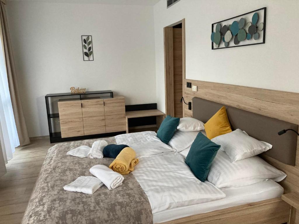 una camera da letto con un grande letto con cuscini sopra di Dani Wellness Apartman a Zalakaros