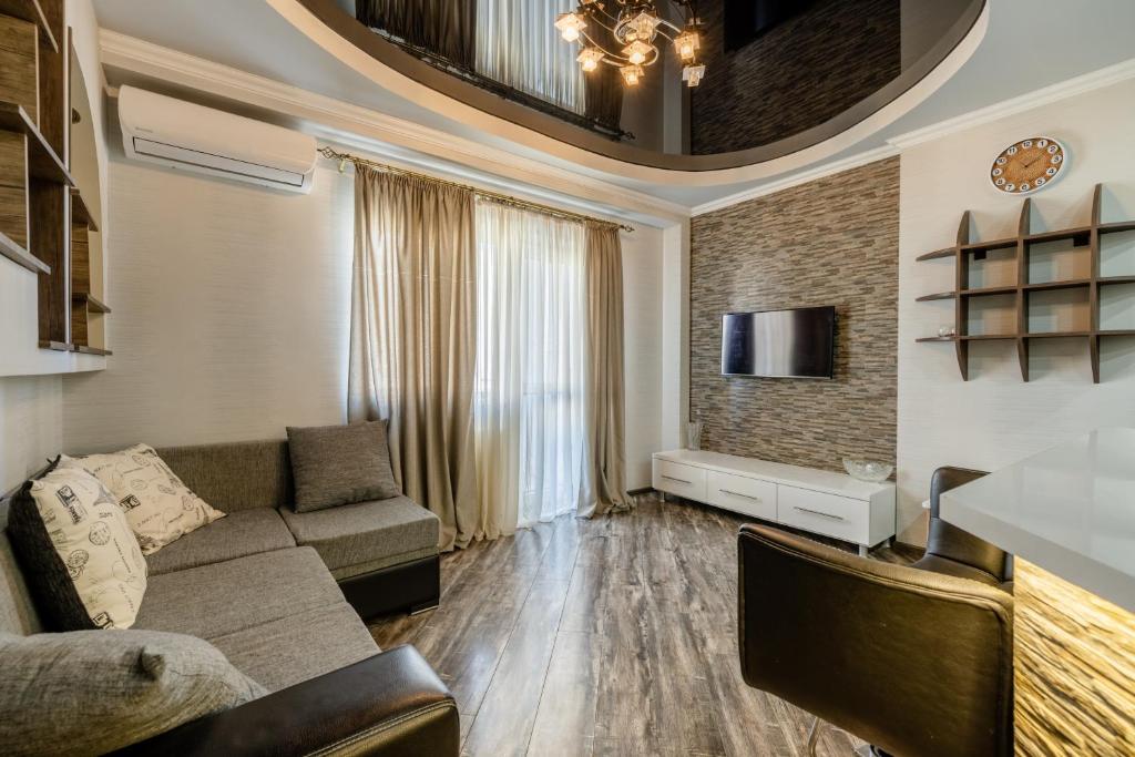 a living room with a couch and a tv at Cozy Apartment in Tbilisi City
