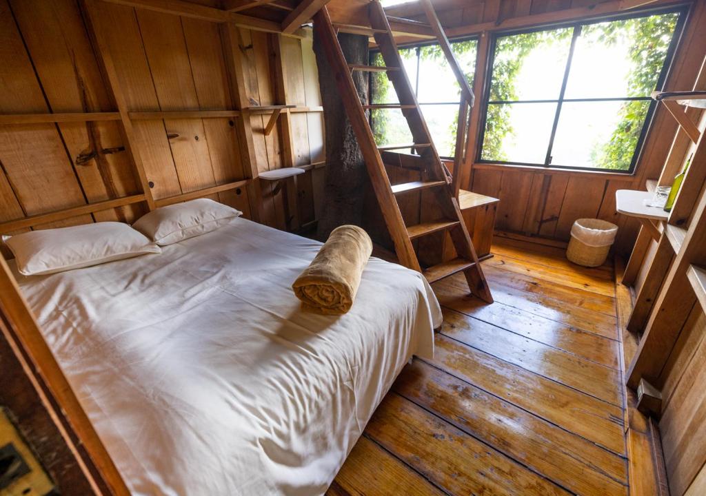 1 dormitorio con 1 cama en una habitación de madera en Earth Lodge, en Antigua Guatemala