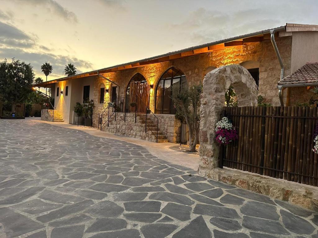 una casa con entrada de piedra frente a un edificio en Hagafen Boutique Suites, en Zikhron Ya‘aqov