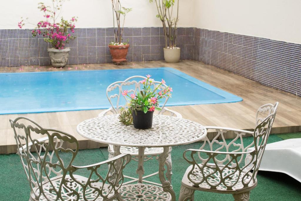 a table and chairs in front of a swimming pool at Recanto da Sol in Belo Horizonte