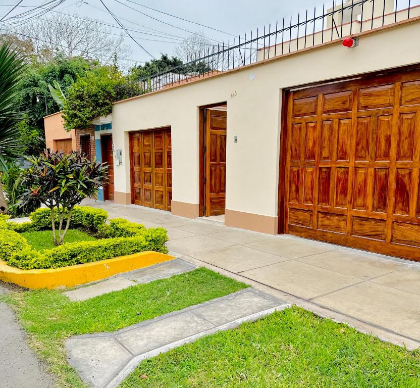 a pair of wooden garage doors on a house at Casa Verde Jesús María - Zona Residencial in Lima