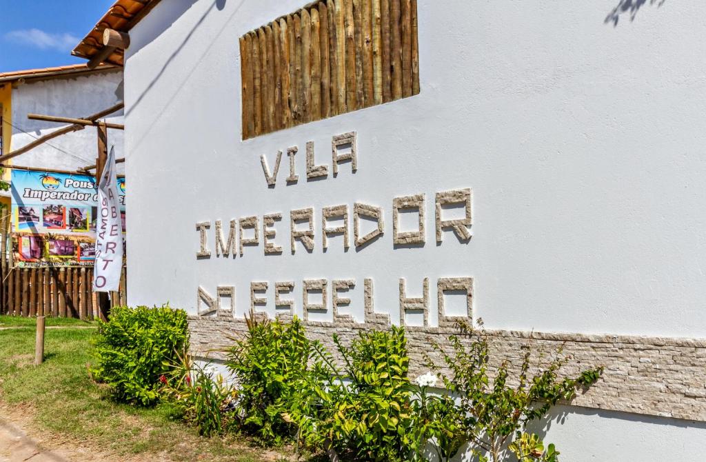 Un edificio bianco con le parole vince l'intervento scritto sopra. di Pousada Imperador do Espelho a Praia do Espelho