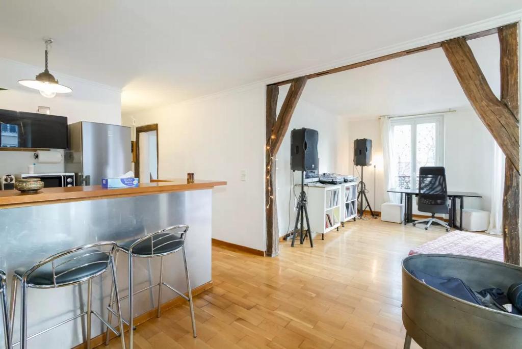 uma cozinha e sala de estar com um balcão e cadeiras em Appartement Paris Centre Vavin em Paris