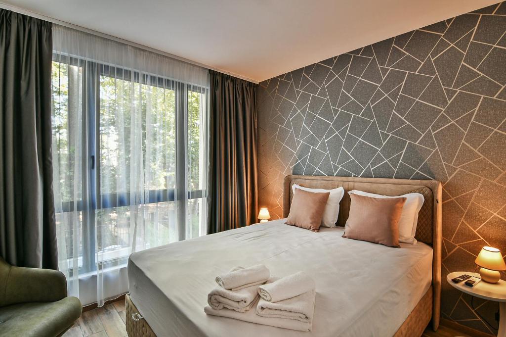 1 dormitorio con 1 cama con toallas en The Shangri-LA flat, en Saints Constantine and Helena