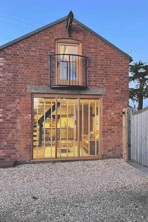 a brick building with a large window with a balcony at Cedar Cottage in Eckington