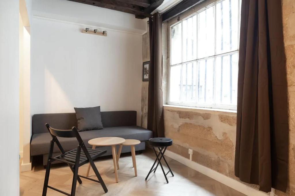 un salon avec un canapé, une table et une fenêtre dans l'établissement Apartment lyonnais center of paris, à Paris