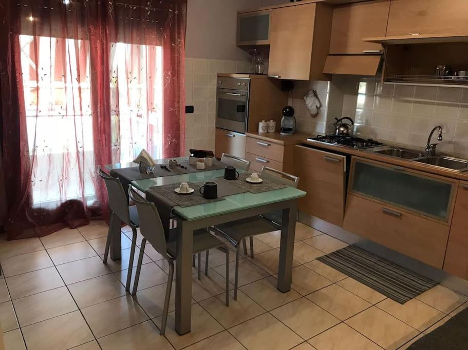 a kitchen with a table and chairs in a kitchen at Appartamento Elegante, Romantico e Riservato in Palazzolo dello Stella