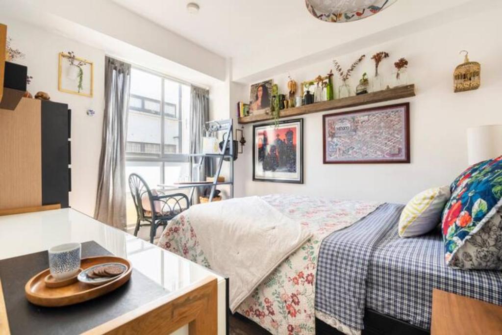 a bedroom with a bed and a table with a hat on it at Pequeña habitacion FRIDA - design CDMX - áreas comunes compartidas in Mexico City