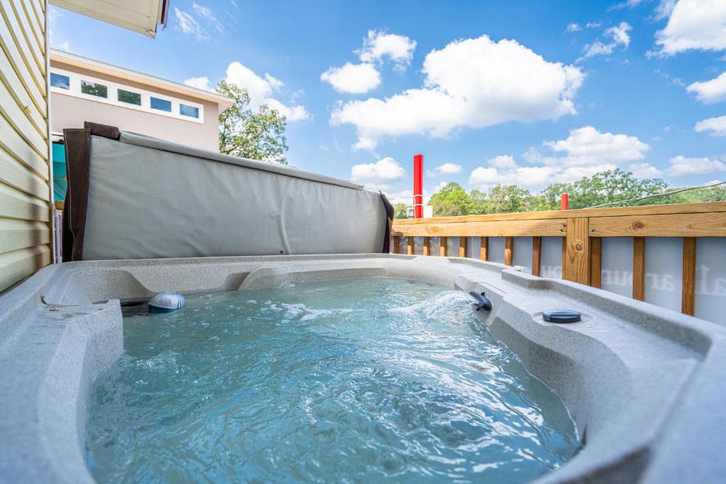 bañera de hidromasaje en la parte trasera de un balcón en Canary Lake Cottage w/Hot Tub at Sam's Pizza, en Hot Springs