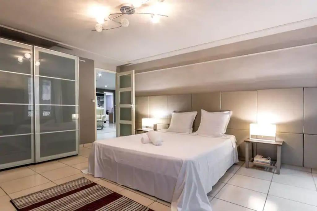 - une chambre avec un grand lit blanc et deux lampes dans l'établissement Appartement au cœur de centre-ville de Marseille, à Marseille