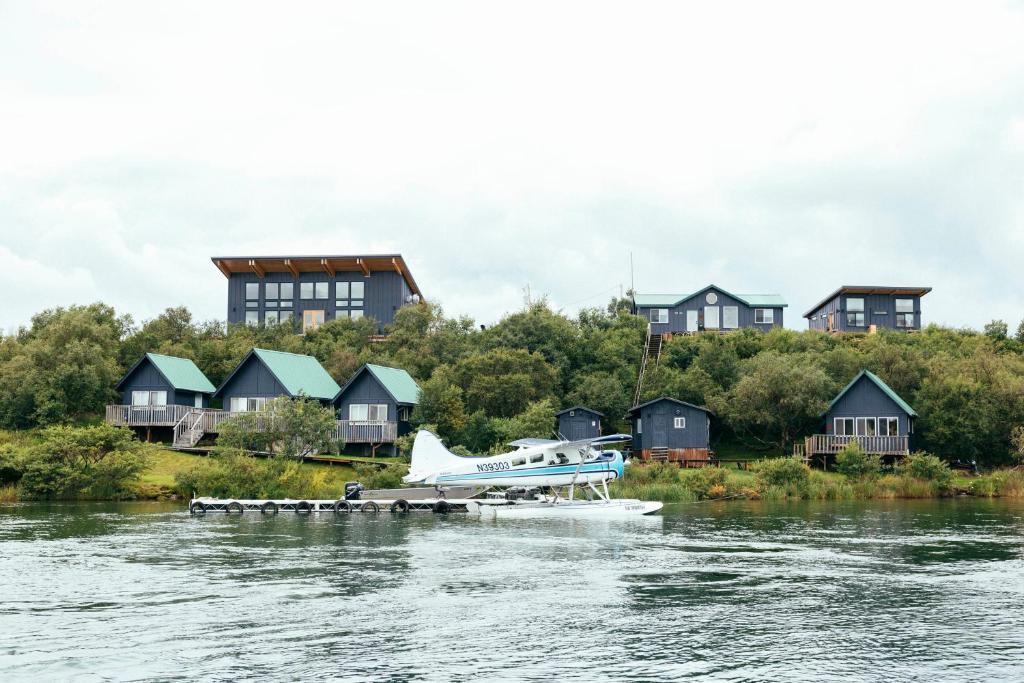 a plane on a dock on the water with houses at The Lodge at 58* North in King Salmon