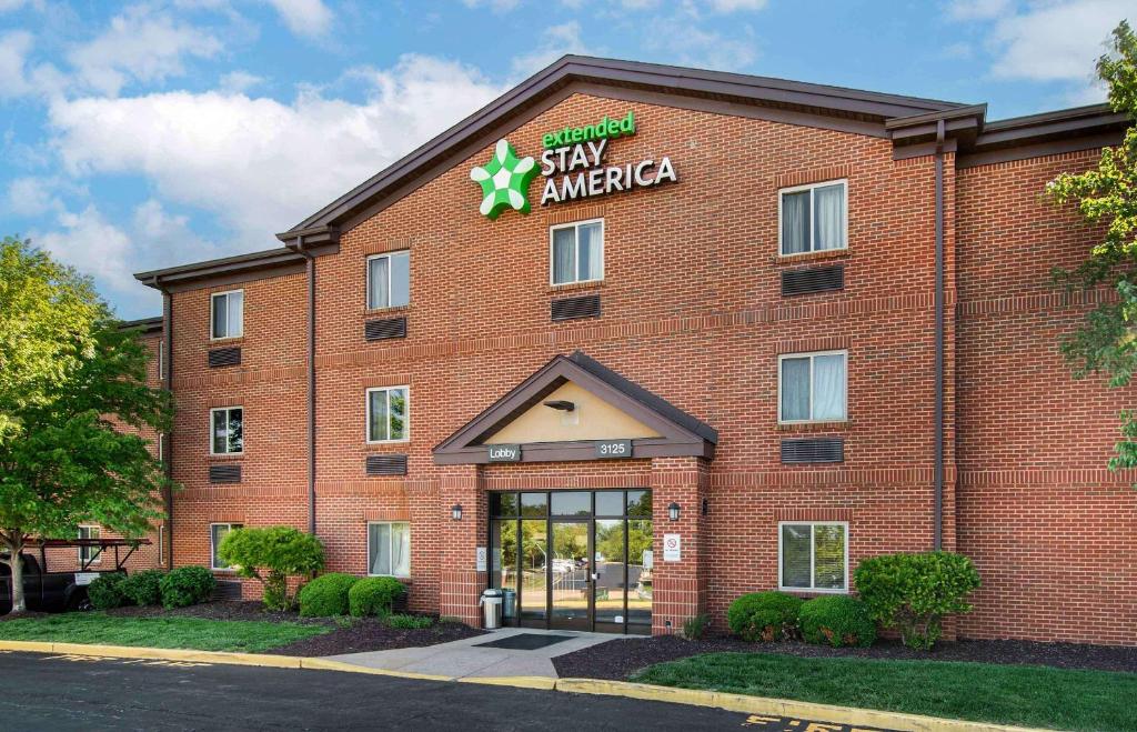 a large red brick building with a sign on it at Extended Stay America Select Suites - St Louis - Earth City in Earth City