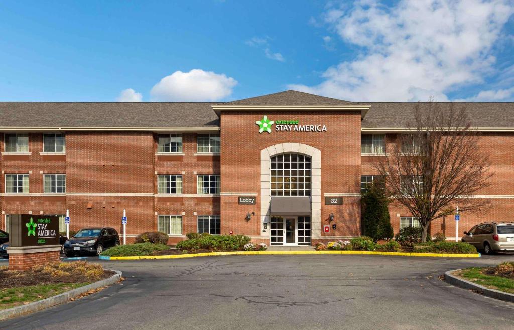 a large red brick building with a star sign on it at Extended Stay America Suites - Boston - Waltham - 32 4th Ave in Waltham