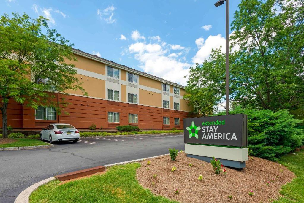 una señal frente a un edificio en Extended Stay America Suites - Piscataway - Rutgers University, en Randolphville