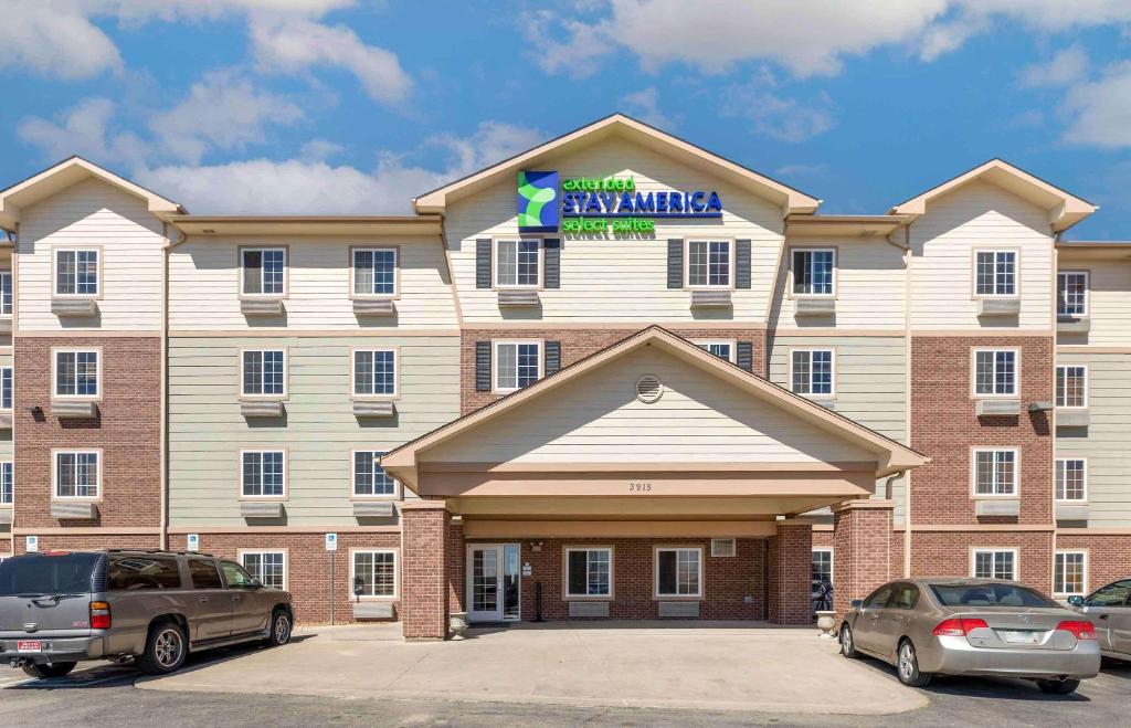 um grande edifício com carros estacionados em frente em Extended Stay America Select Suites - Loveland em Loveland