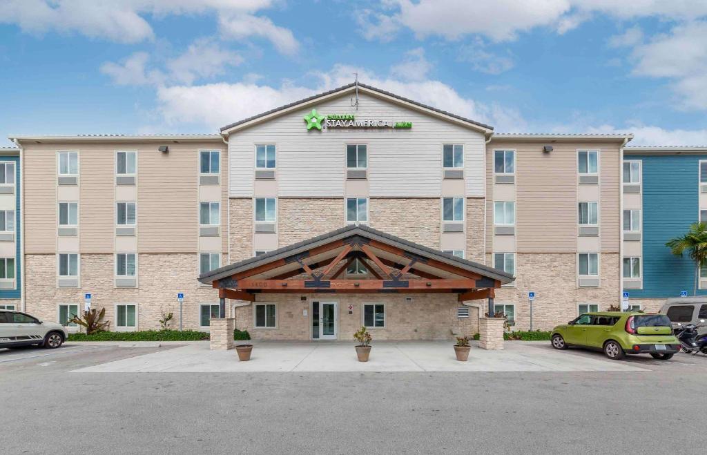 a large hotel building with cars parked in a parking lot at Extended Stay America Select Suites - Deerfield Beach in Deerfield Beach
