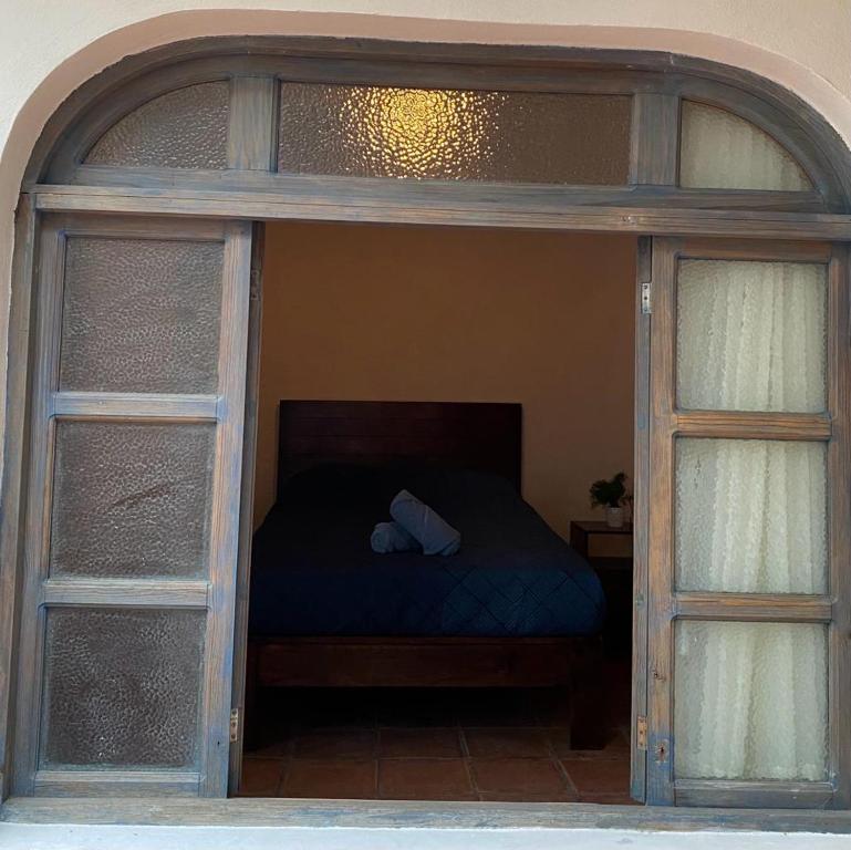 a bed in a room with two glass doors at Casa Laberinto in San Miguel de Allende