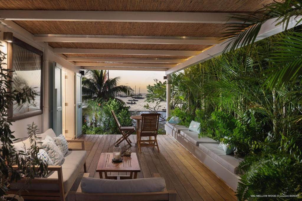 a patio with a lot of plants and a table at On the Beach , in Saint Barth... Mellow Mood Villa in Saint Barthelemy