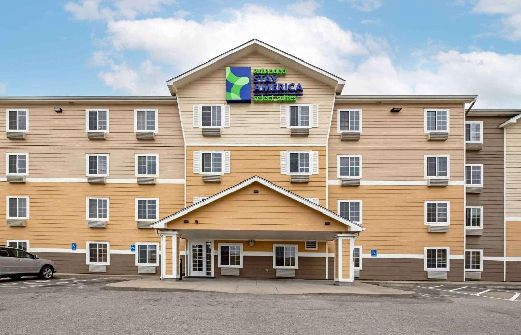 a large hotel with a sign on the front of it at Extended Stay America Select Suites - Wichita - Airport in Wichita