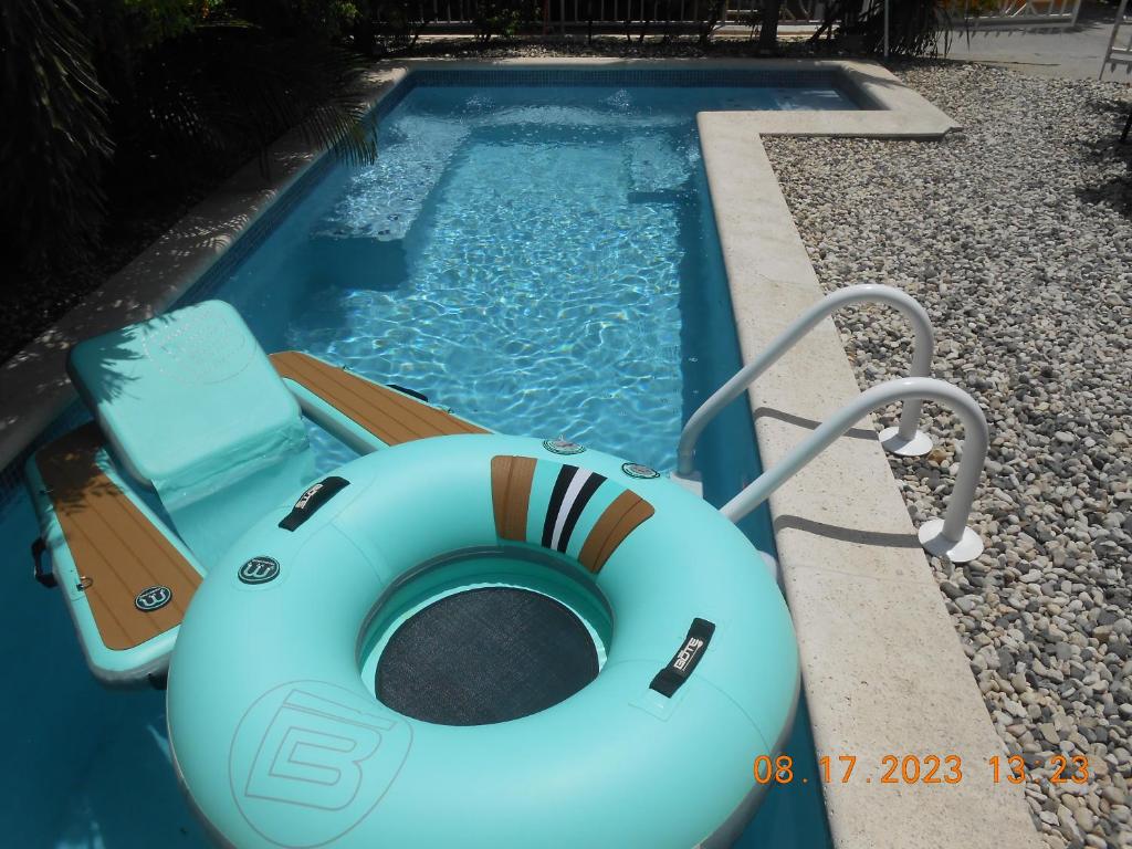 a pool with a raft and a chair in it at Gustave Vacation House in Port-au-Prince