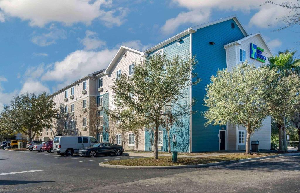 een blauw gebouw aan de straatkant bij Extended Stay America Select Suites - Orlando - South in Orlando