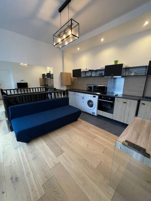 un salon avec un canapé bleu dans une cuisine dans l'établissement confortable appartement 3 pièces Flatters, à Paris