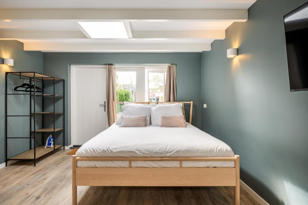 een slaapkamer met een bed en een raam bij Studio Luxe 31 Zandvoort met gratis parkeerplaats in Zandvoort