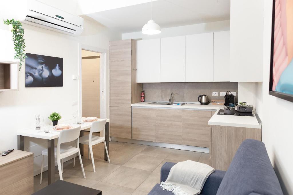 a kitchen and living room with a couch and a table at Monviso Exclusive Apartment in Milan