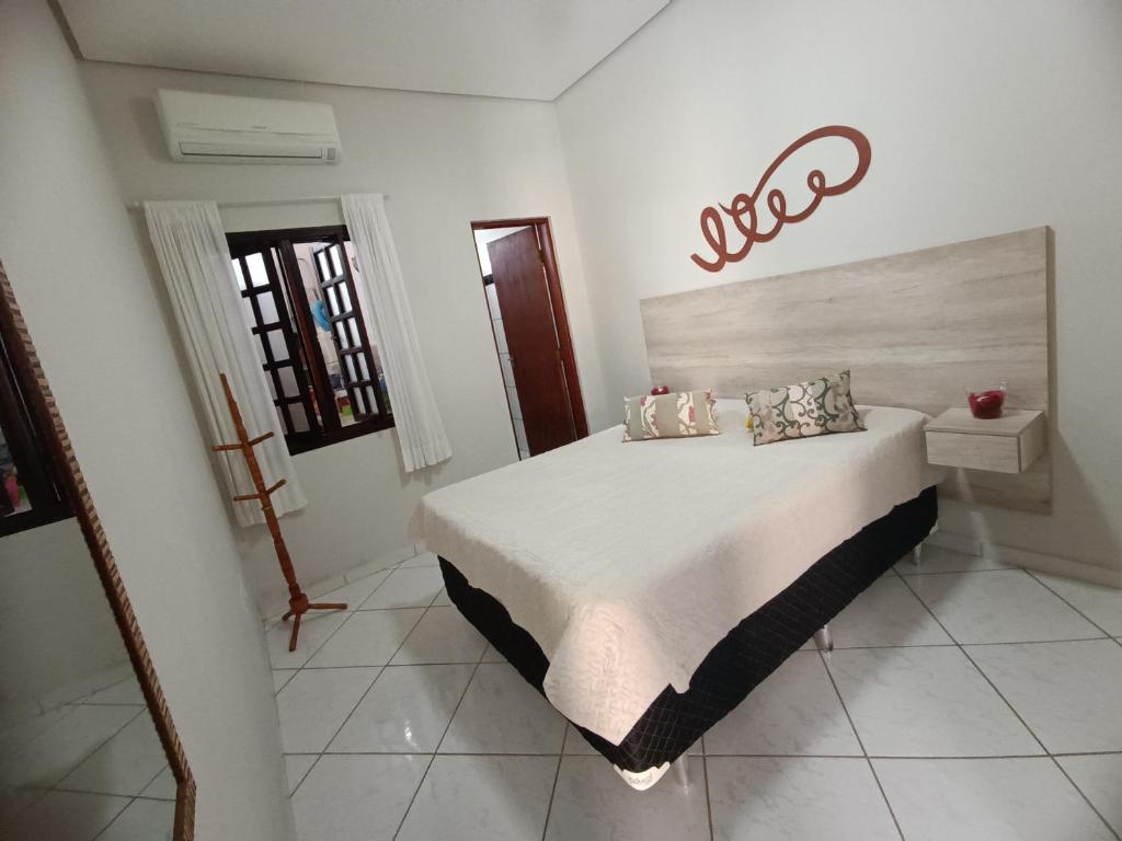 Un dormitorio con una cama grande en una habitación. en Casa de Praia Martins De Sá Condomínio Caraguatatuba, en Caraguatatuba