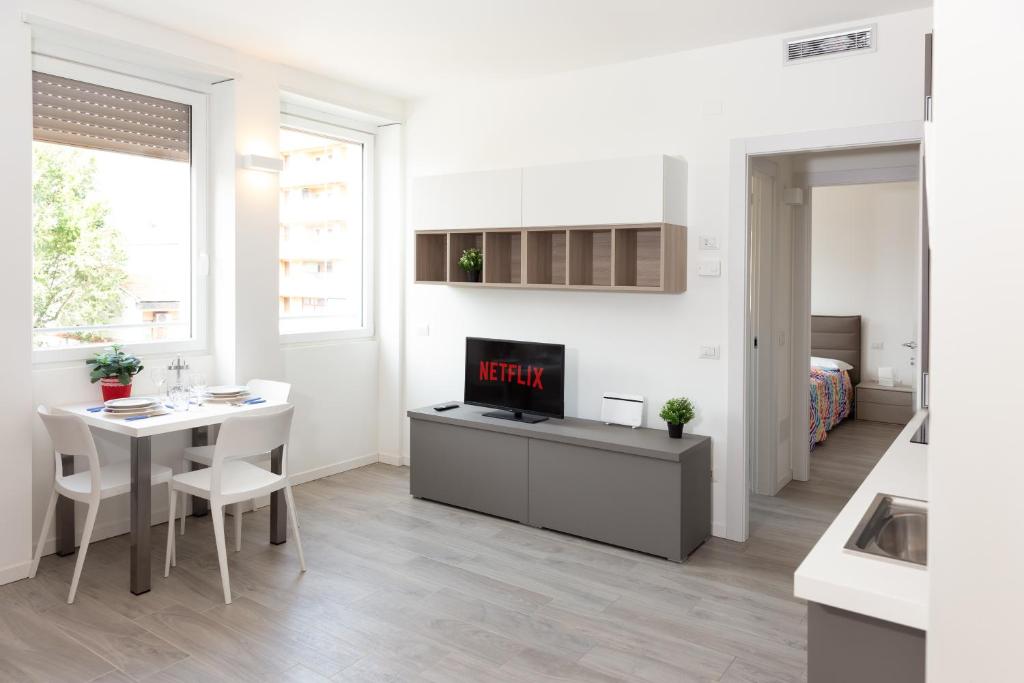 1 dormitorio y sala de estar con mesa y TV. en Van Gogh Exclusive Apartment, en Milán