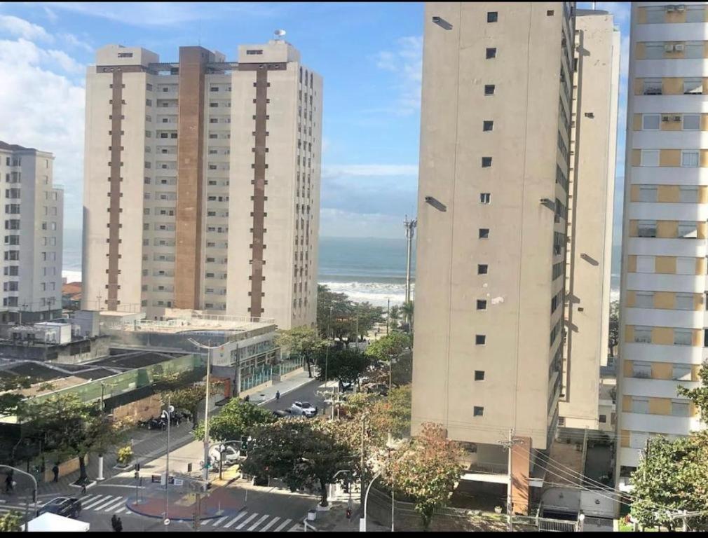 two tall buildings in a city next to the ocean at Beach House 2 in Guarujá